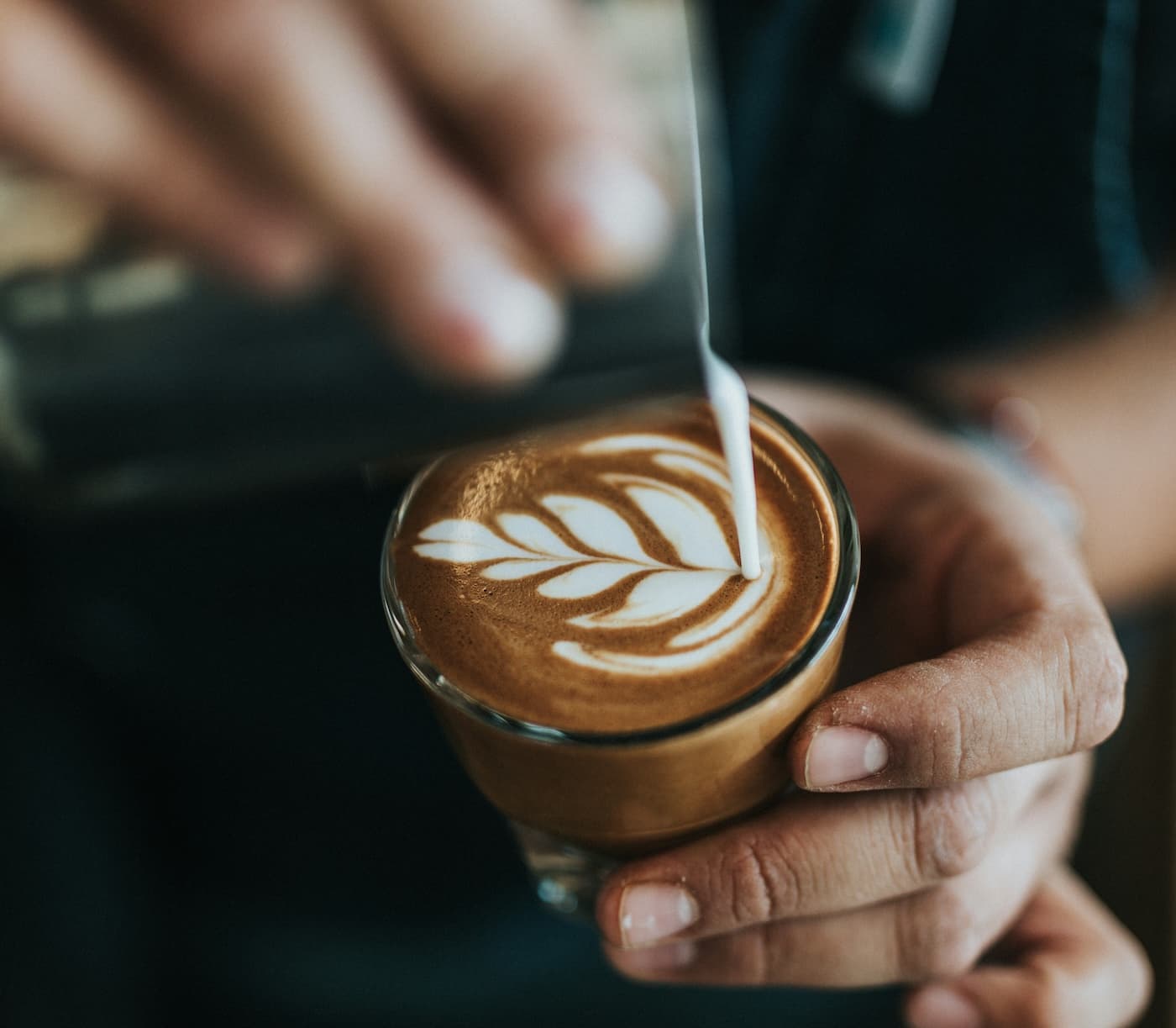 A leaf being added to latte foam